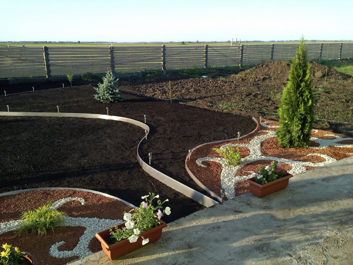 Клумба с бордюрной лентой и камнями