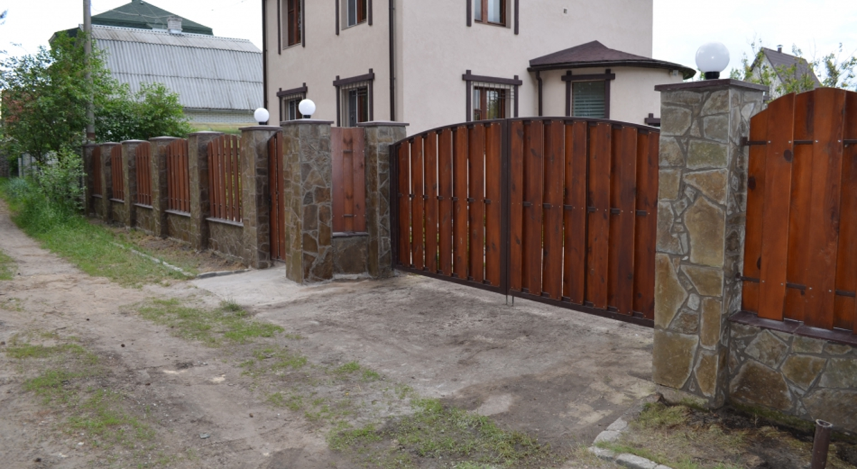 Деревянный забор с каменными столбами