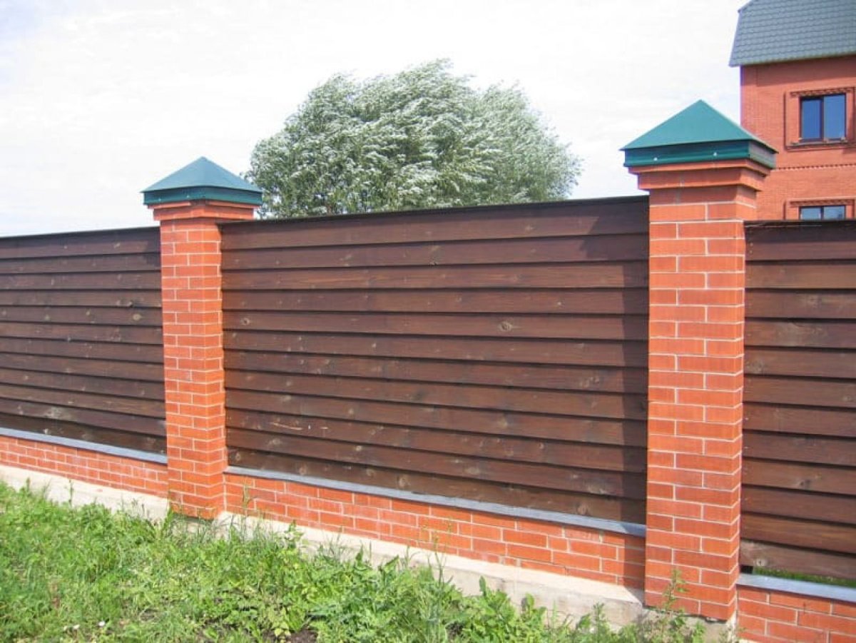 Деревянный забор с кирпичными столбами