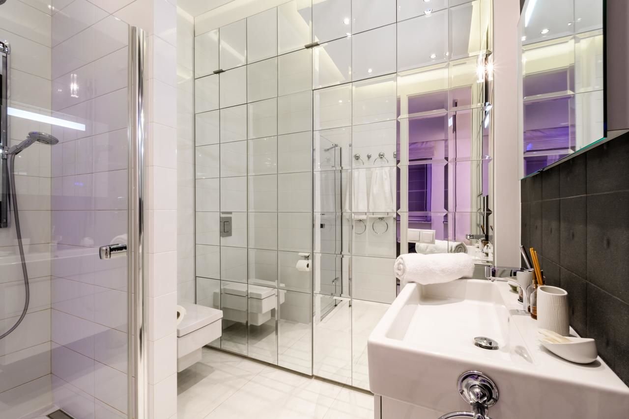 Зеркала в плитке ванной комнаты. Зеркальная стена в ванной. Ванная комната с зеркальной стеной. Зеркальная плитка в ванной комнате. Зеркальная стена в санузле.