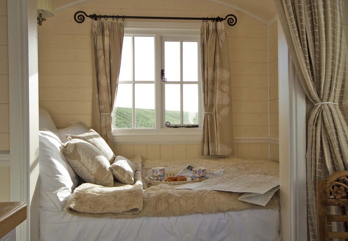 Кровать около окна в спальне