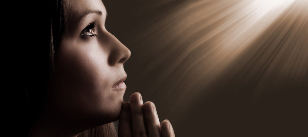 Женщина молится на коленях