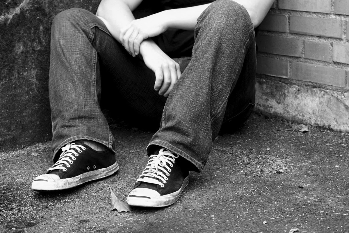 Парень сидит на дороге