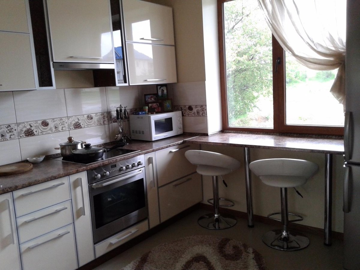 Угловая кухня с окном и барной стойкой