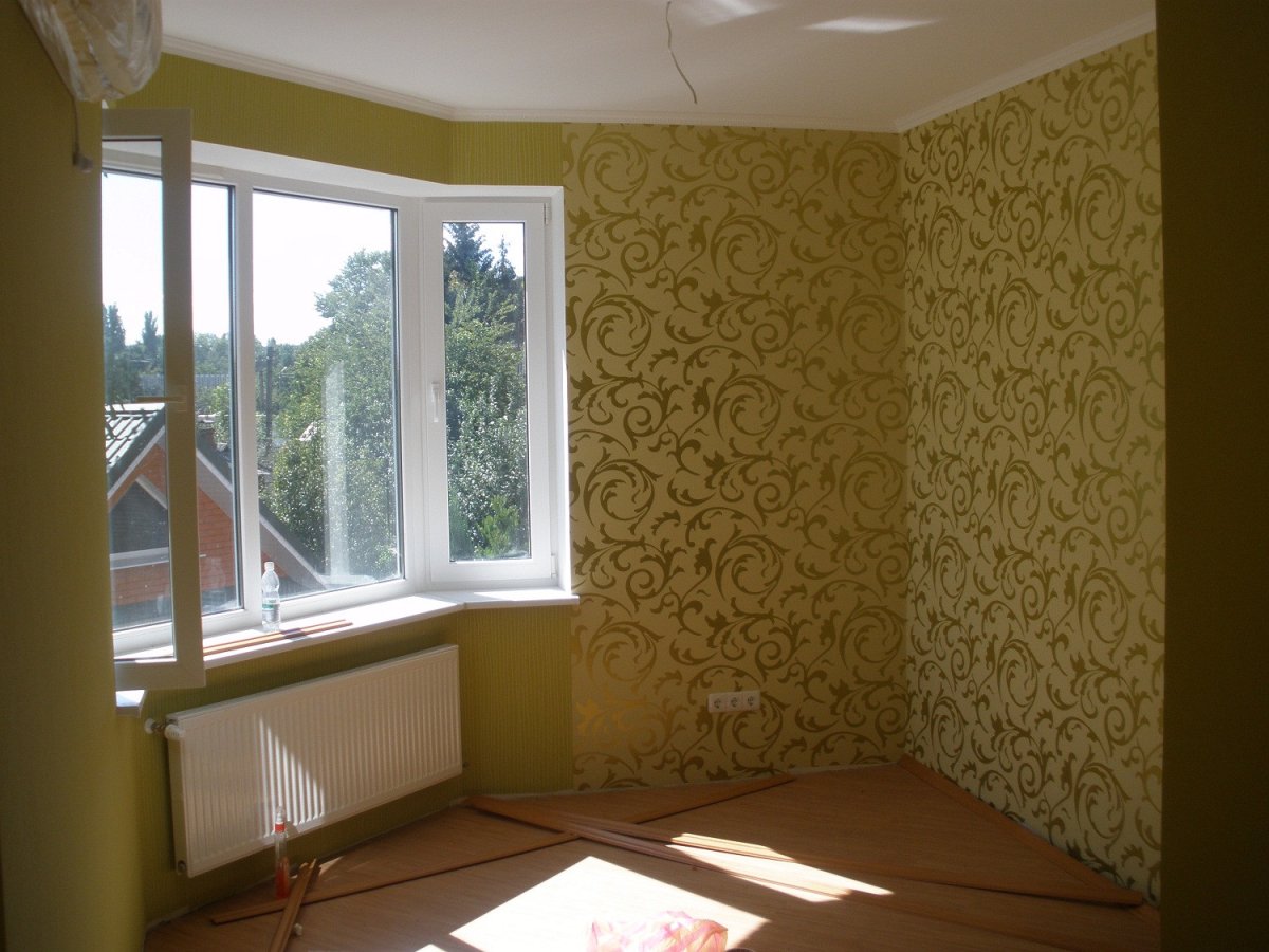 Человек красит стену