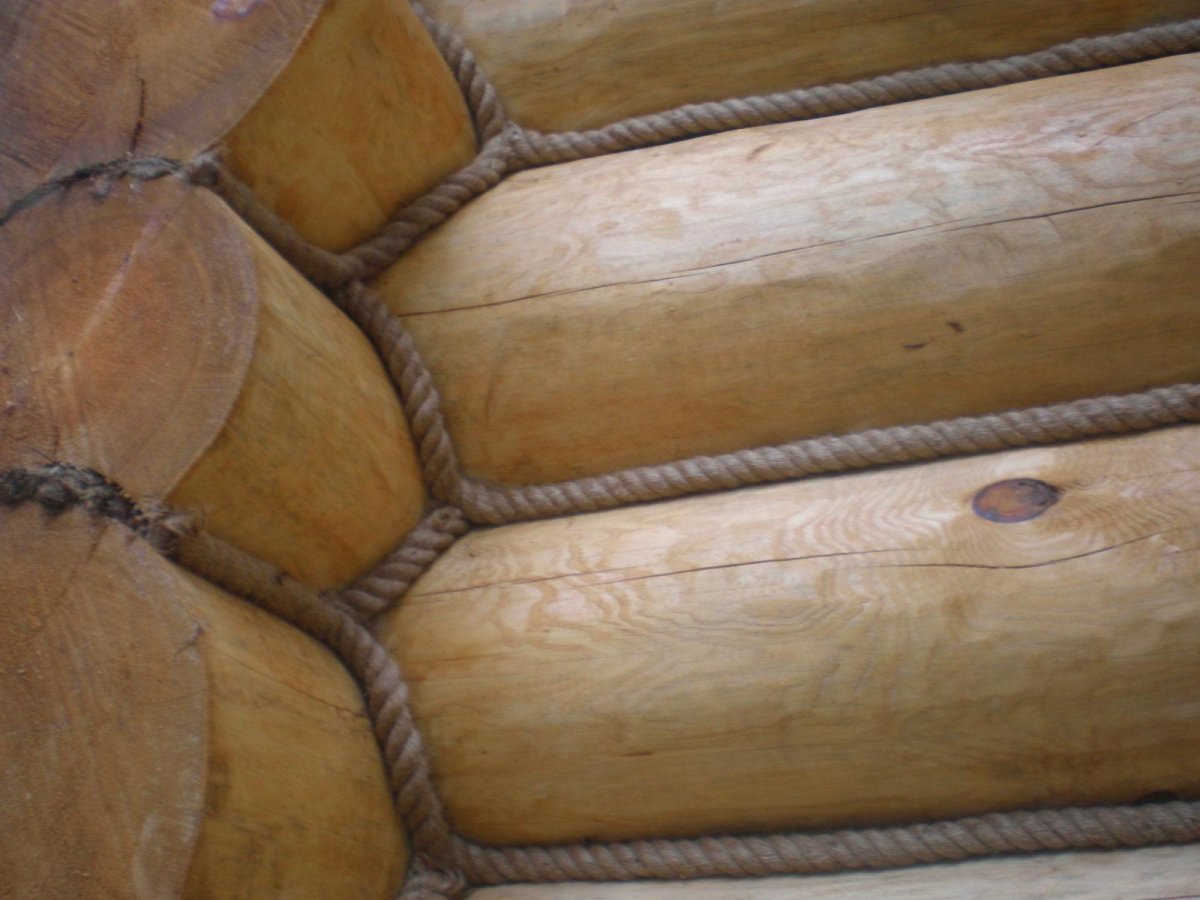 Конопатка оцилиндрованного бревна джутом