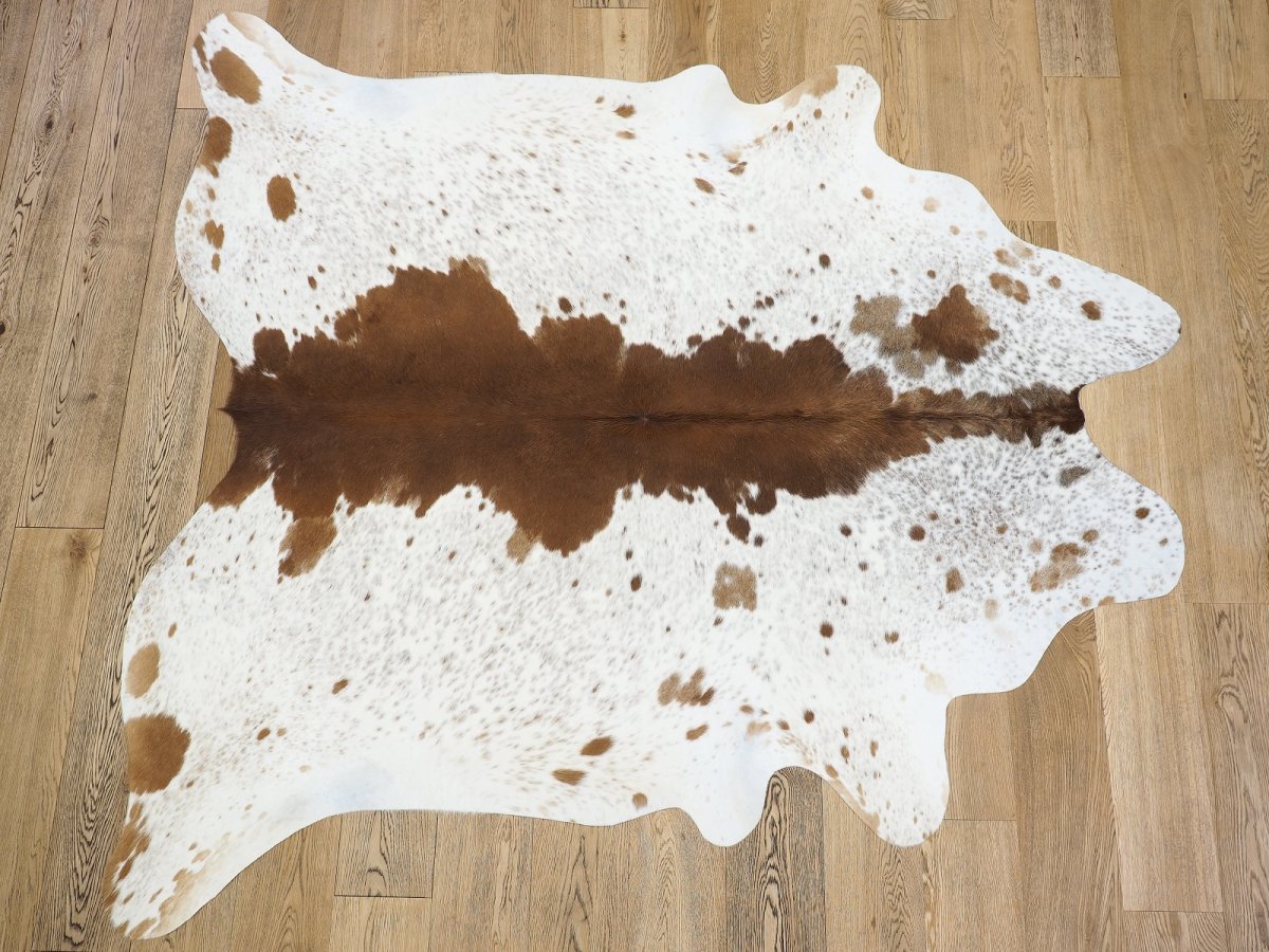 Коричневая коровья шкура на паркете
