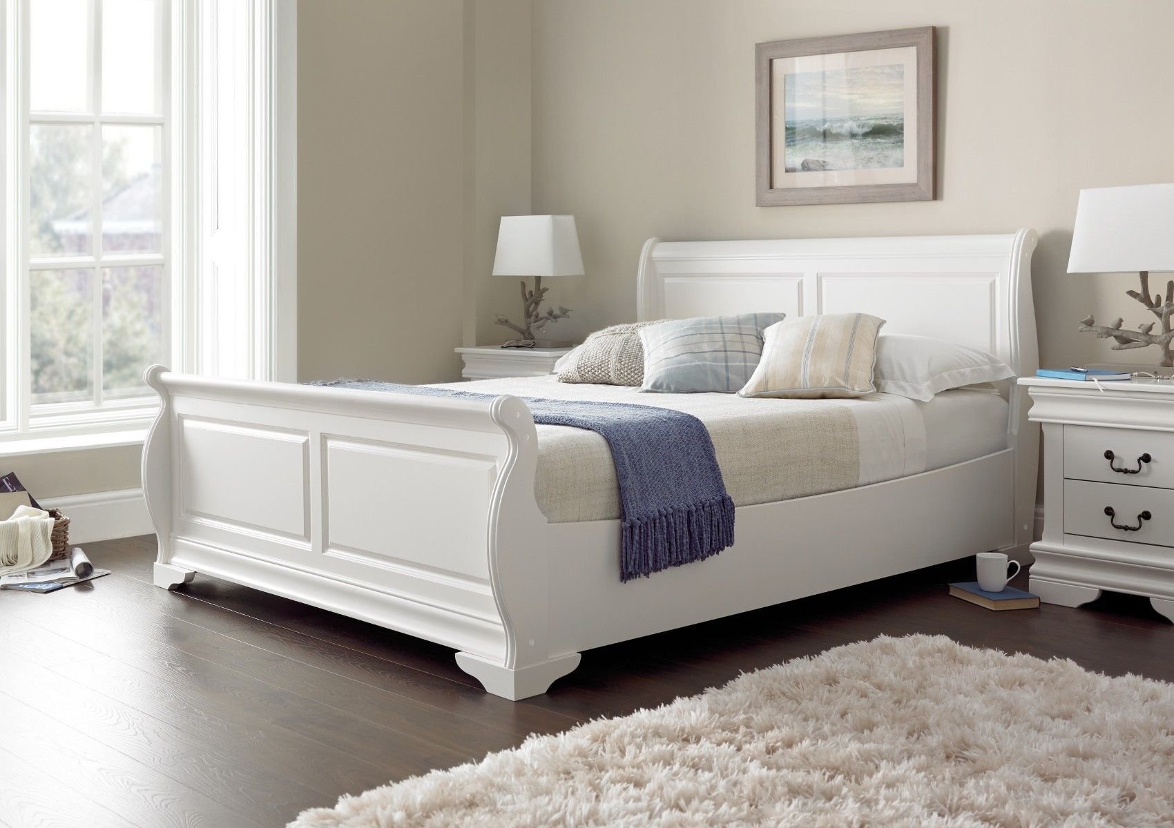 белая кровать с деревянным изголовьем