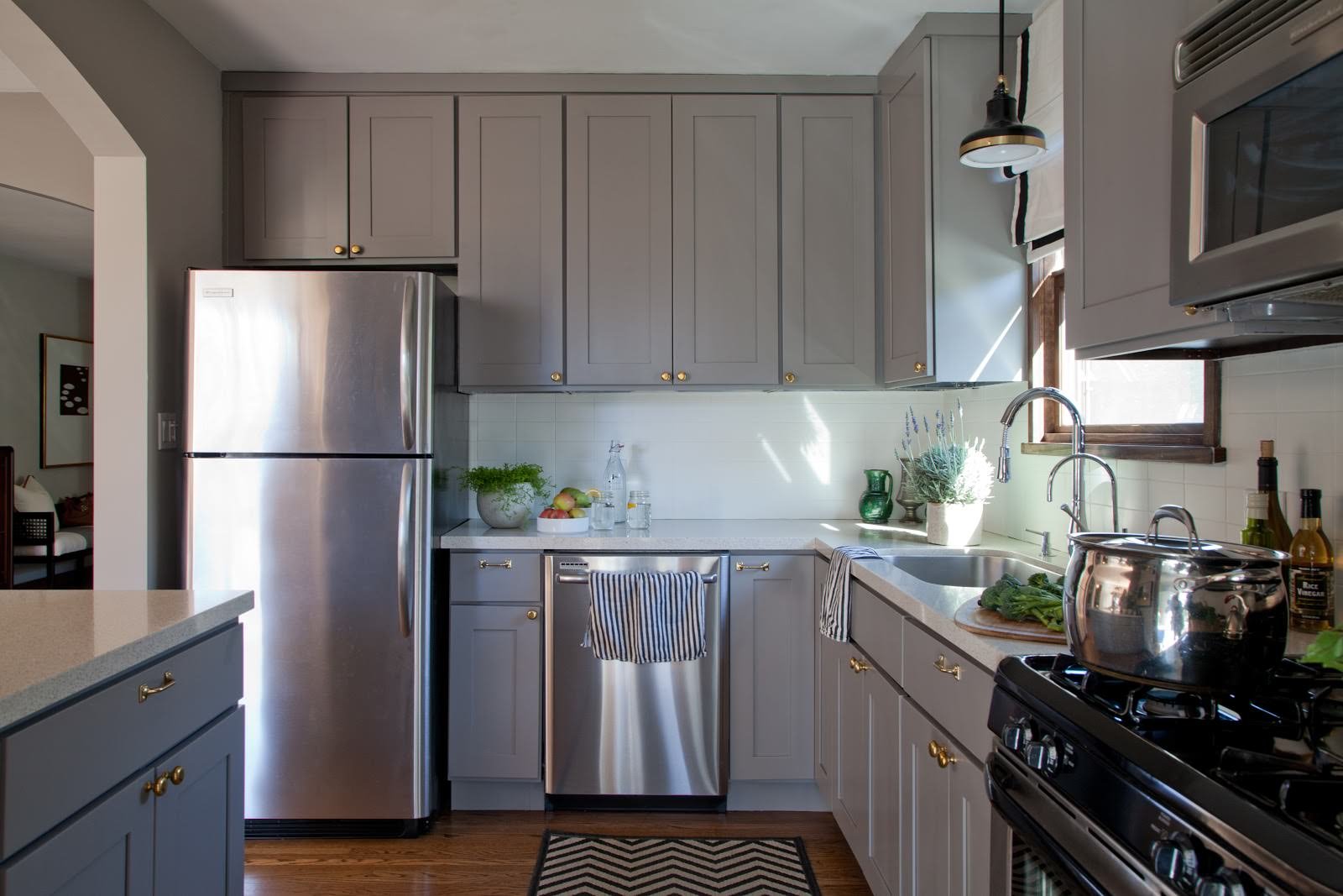 серый холодильник в интерьере белой кухни с деревянной столешницей фото