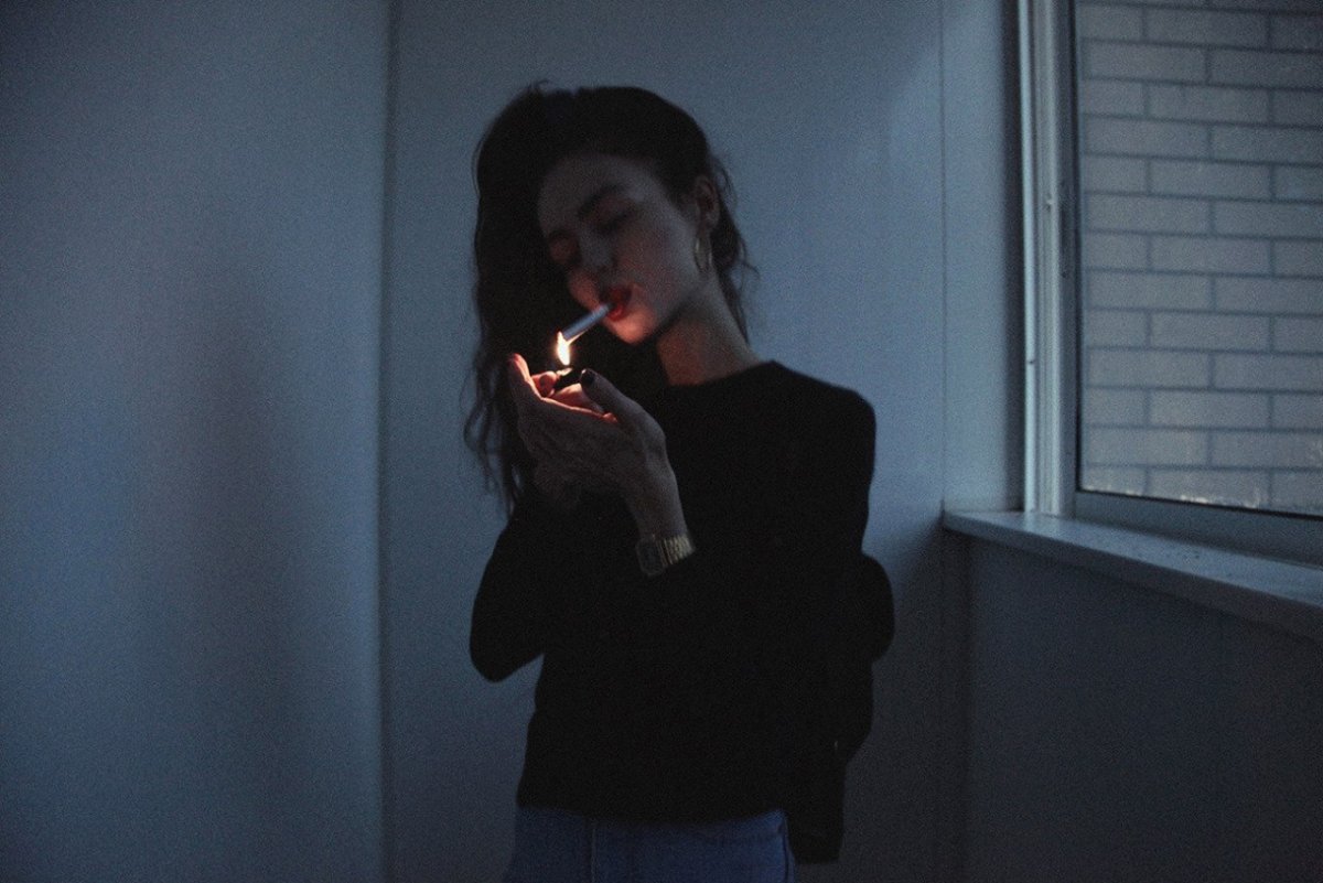 Девушка курит в темноте