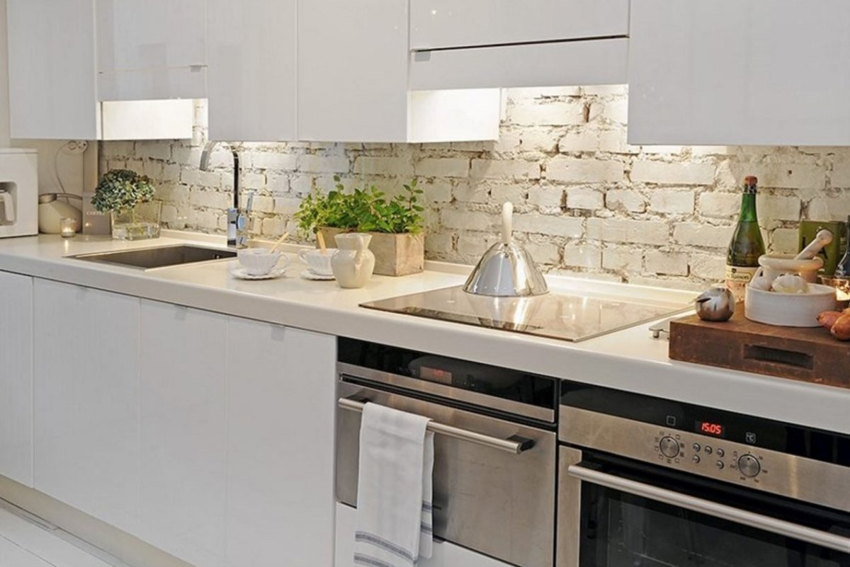 Белая кухня с кирпичным фартуком
