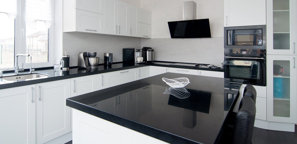 Черный холодильник в интерьере белой кухни