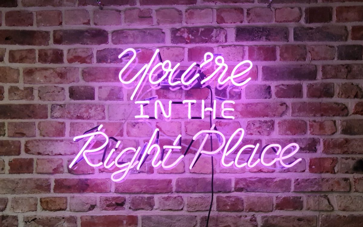 Неоновая вывеска на кирпичной стене