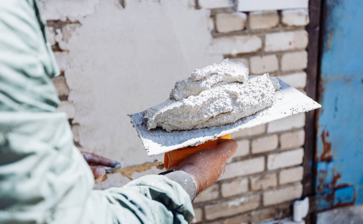 Рабочий красит стену