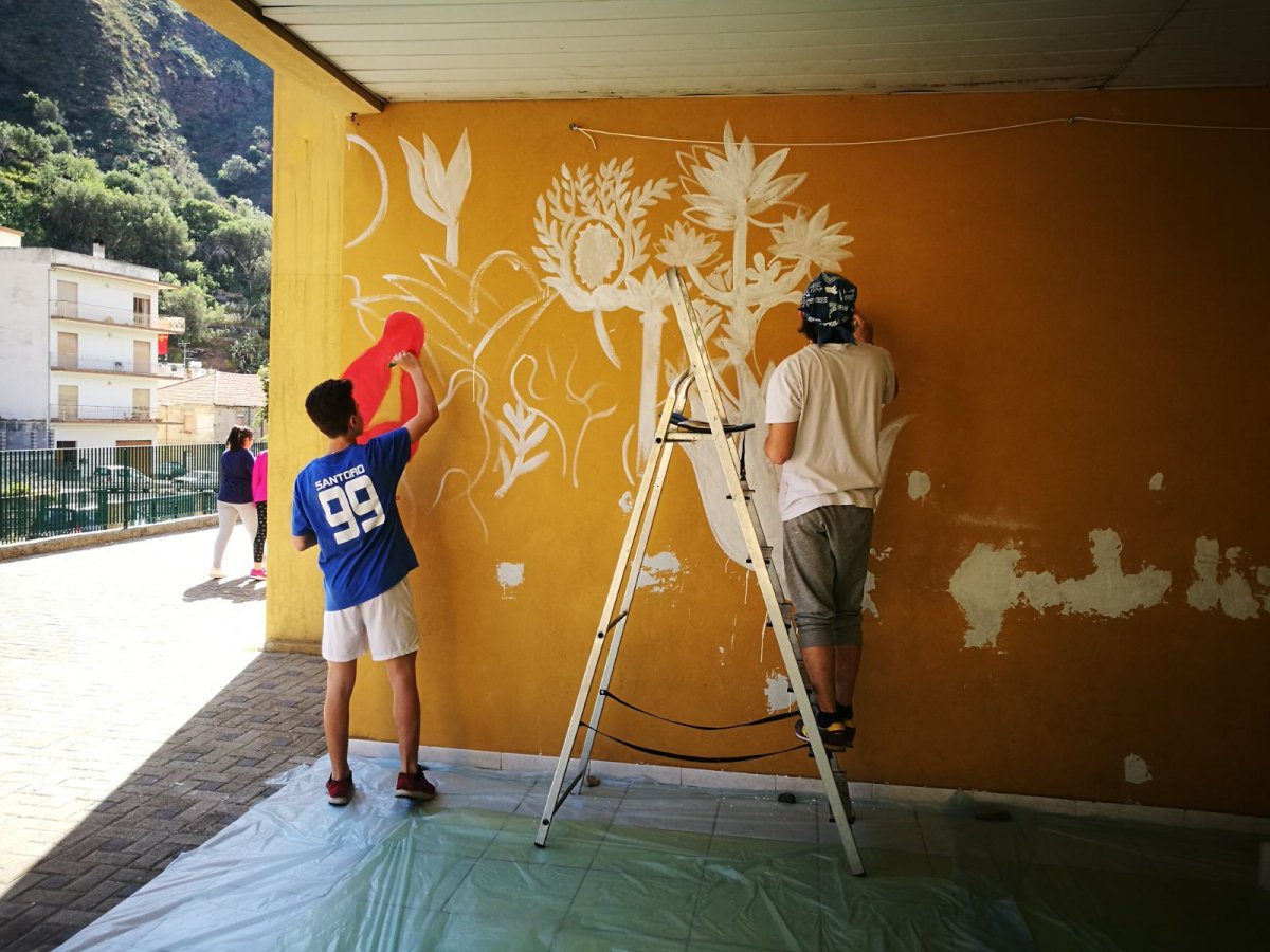 Мальчик красит стену