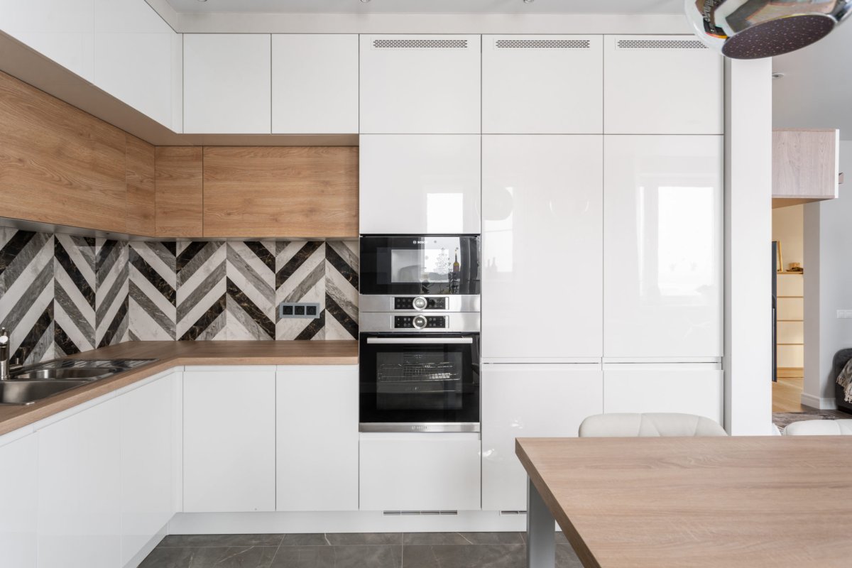 Белая кухня с деревянной столешницей и фартуком пэчворк