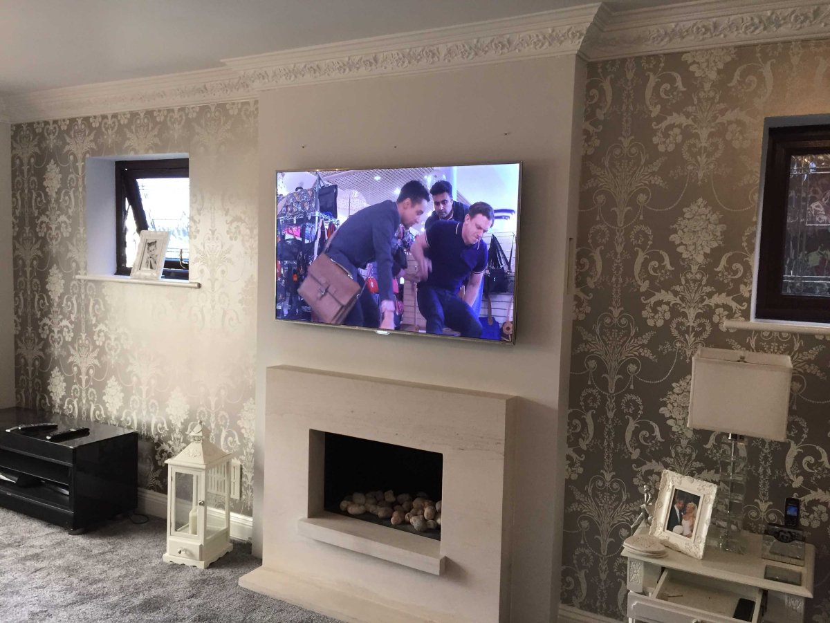 Декоративный камин в гостиной с телевизором