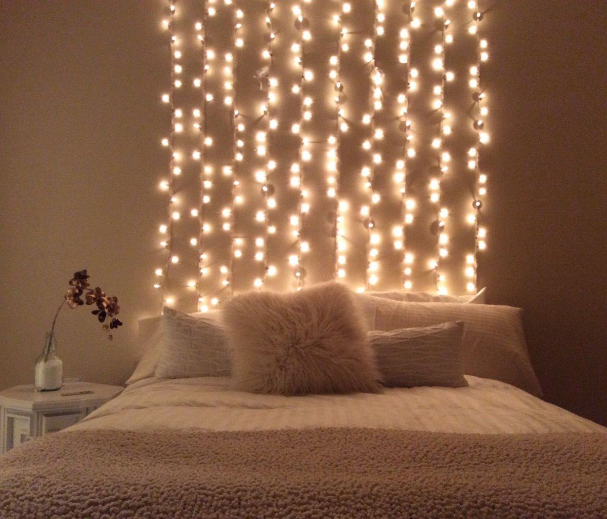 Гирлянды на стене над кроватью