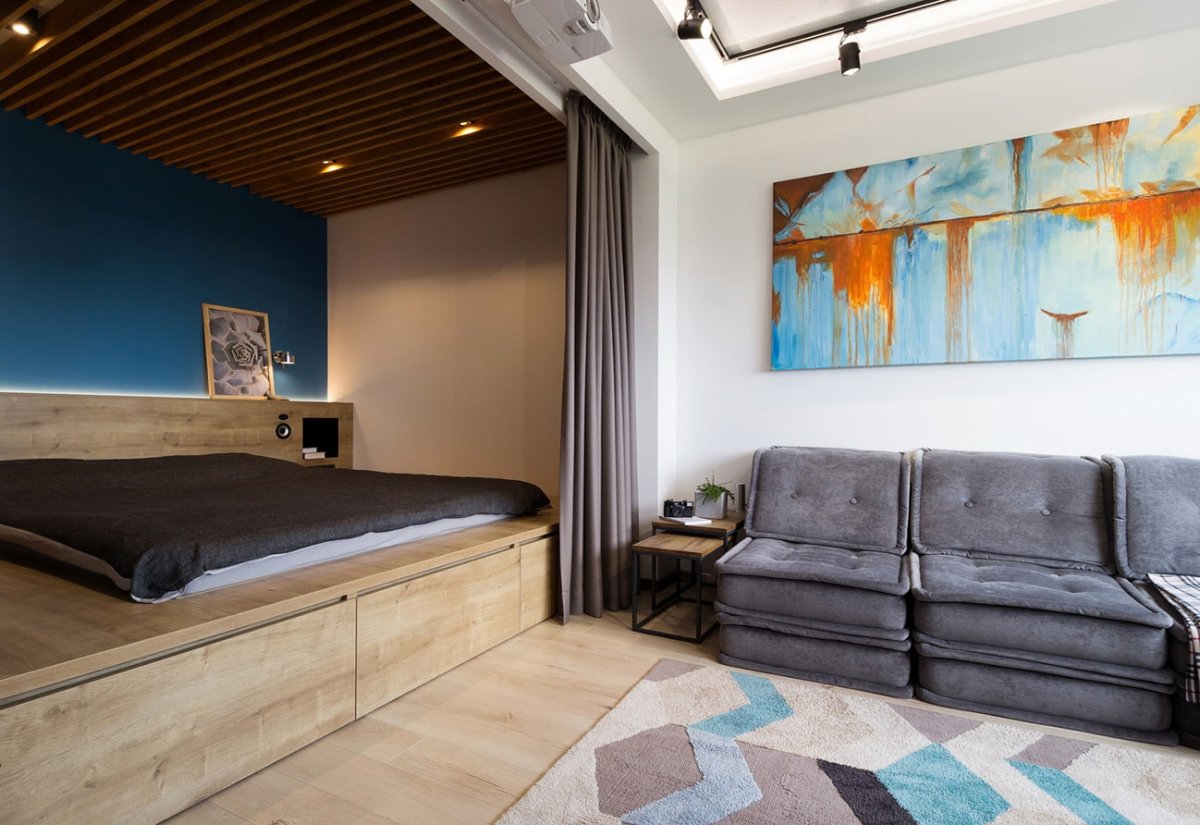 Кровать на подиуме в интерьере студии