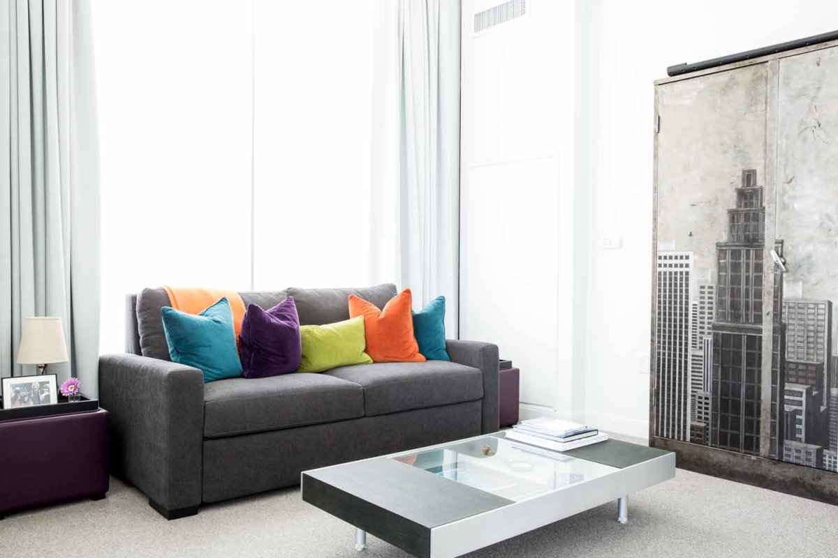 Серый диван с яркими подушками