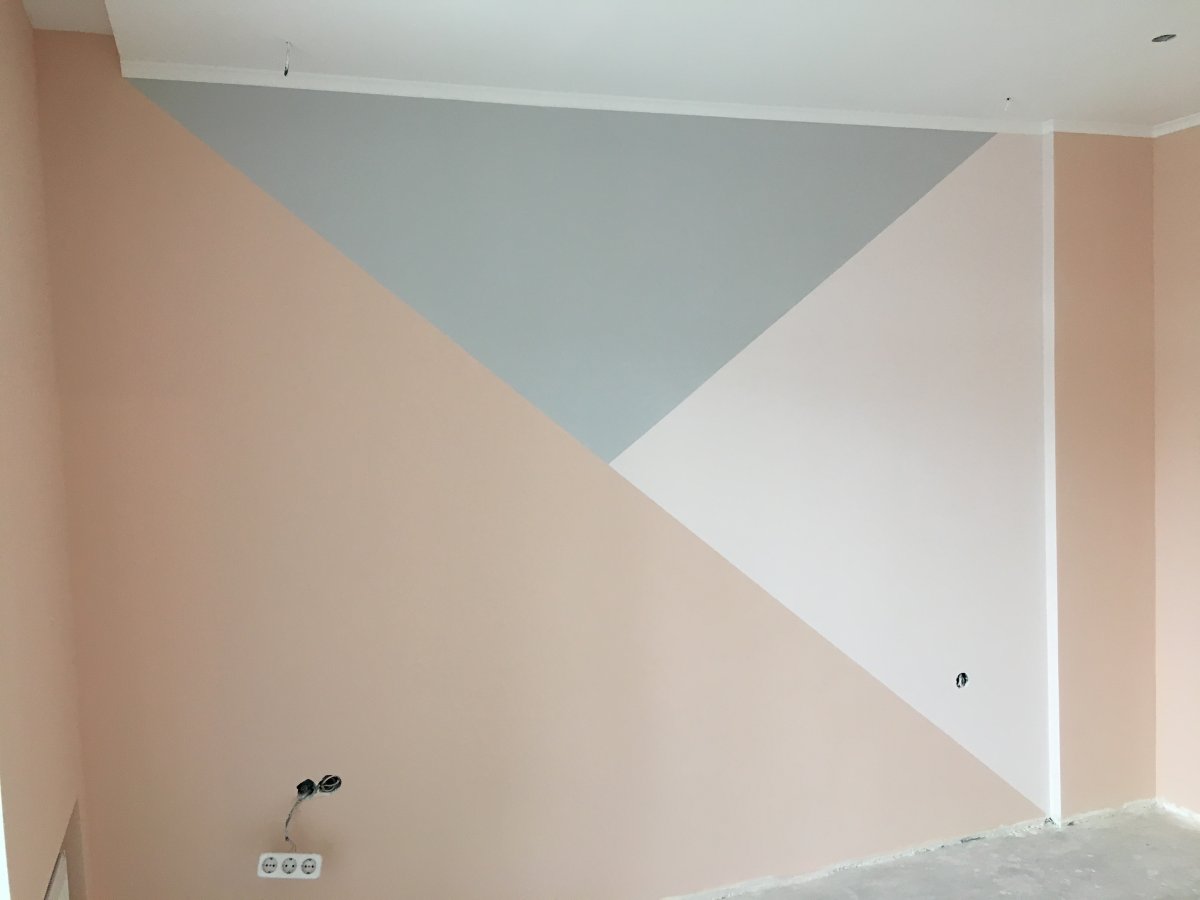 Человек красит стену