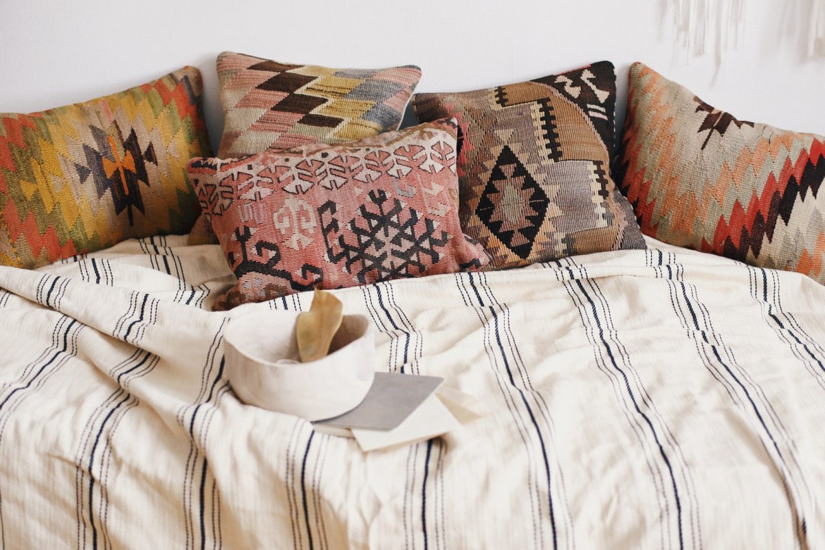 Серый кожаный диван с коричневыми болотными подушками