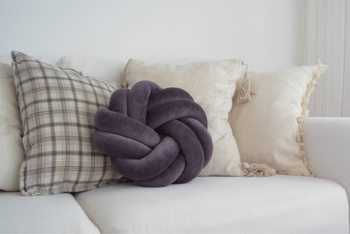 Коричневый кожаный диван с цветными подушками