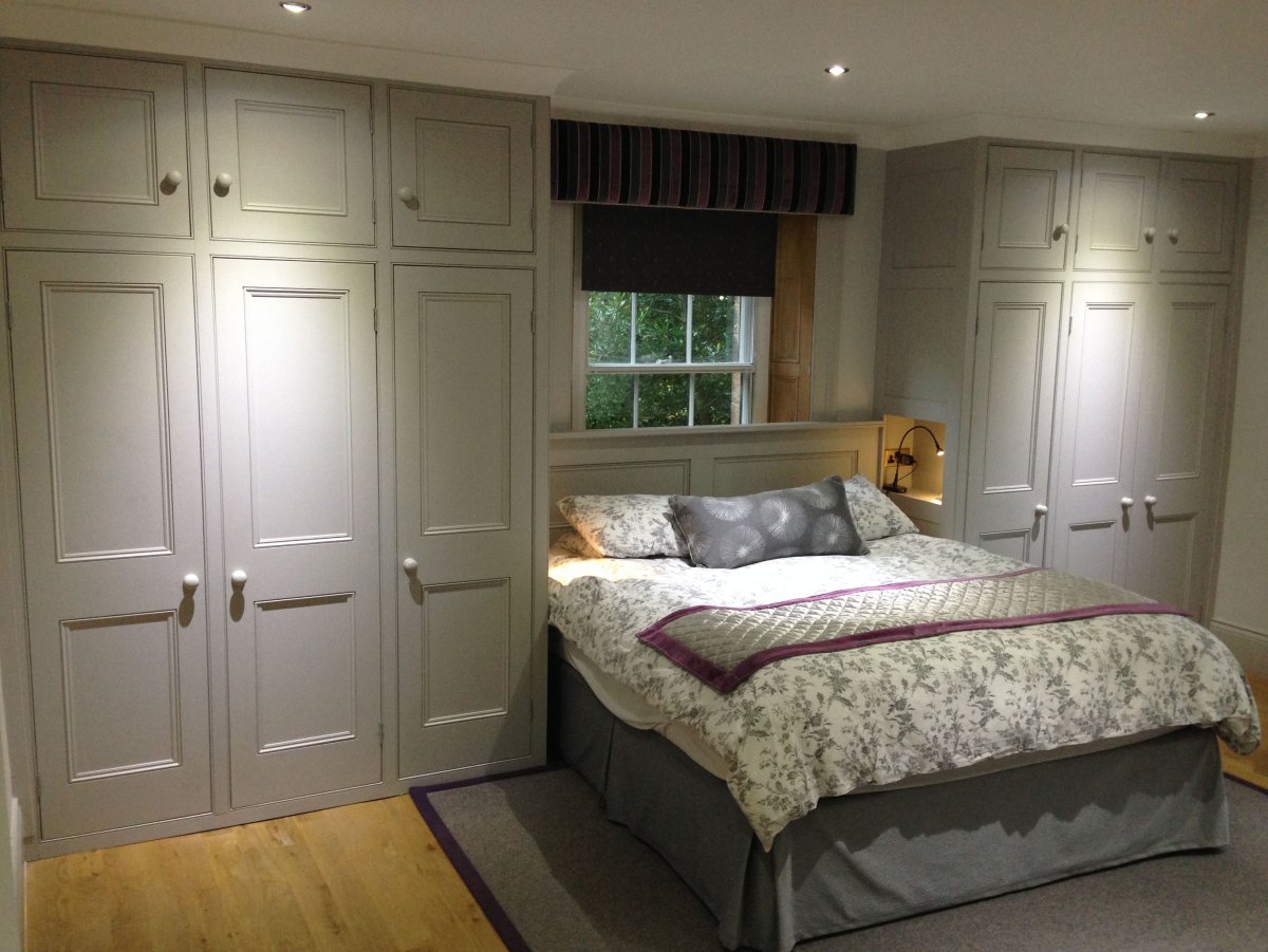 Гардеробная в спальне с двуспальной кроватью