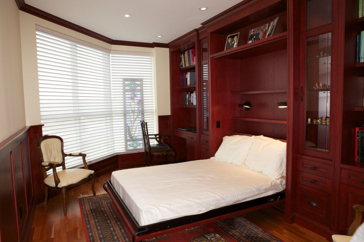 Шкафы и кровать у окна спальни