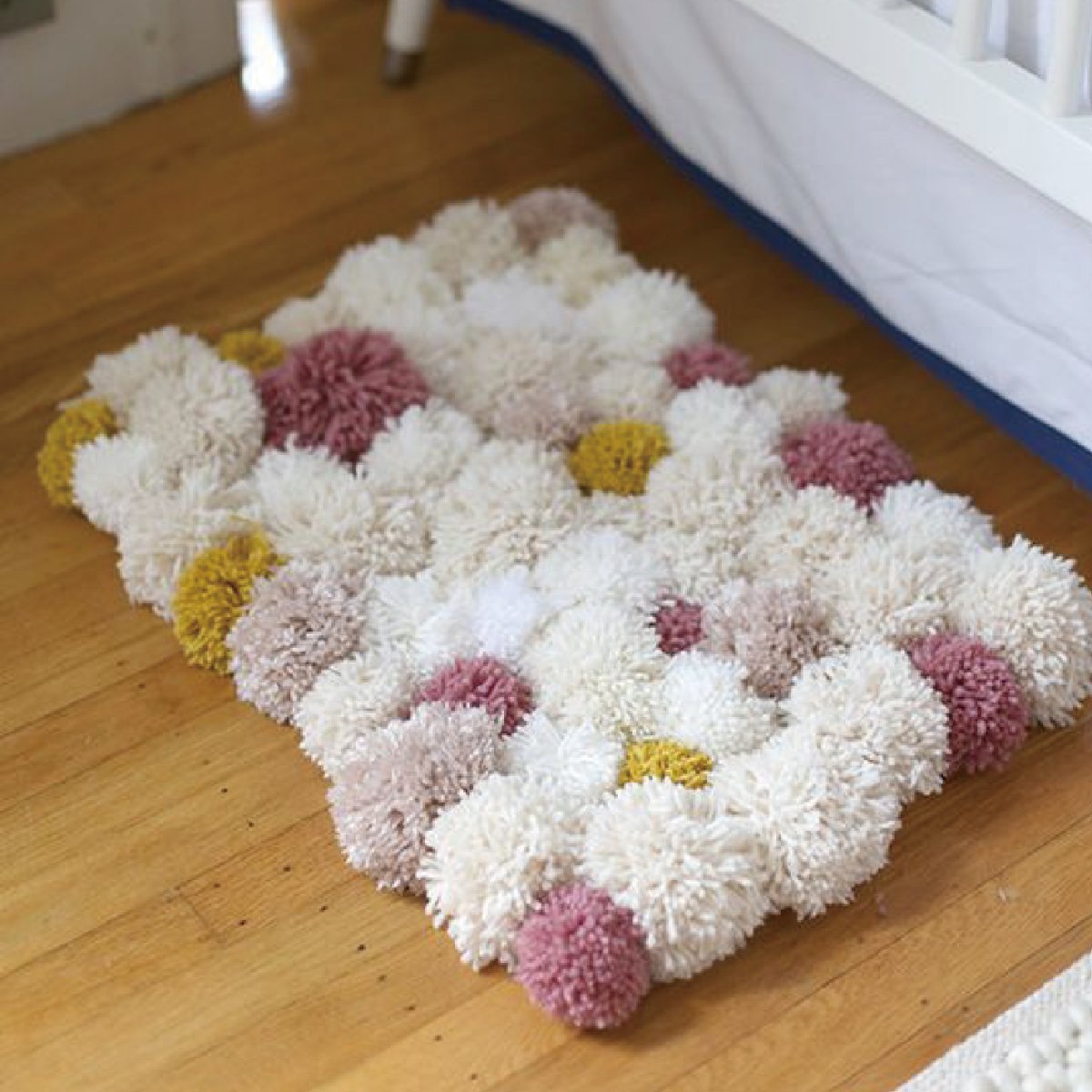 Вязаный коврик из помпонов
