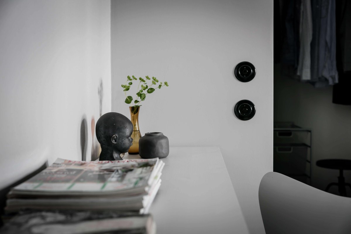 Черные выключатели в интерьере на белых стенах